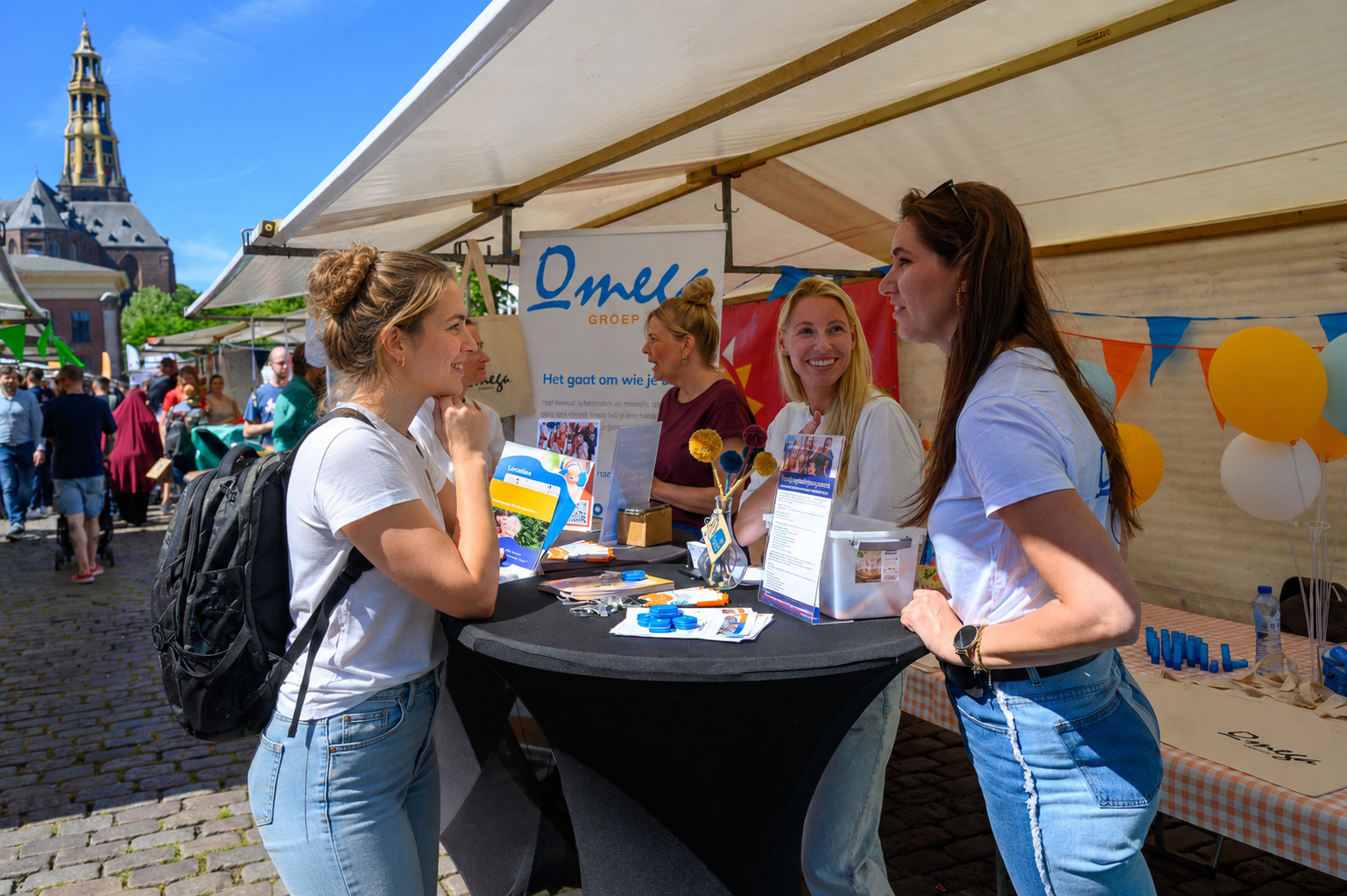 Bezoekers in gesprek met een standhouder op De Banenmarkt Groningen