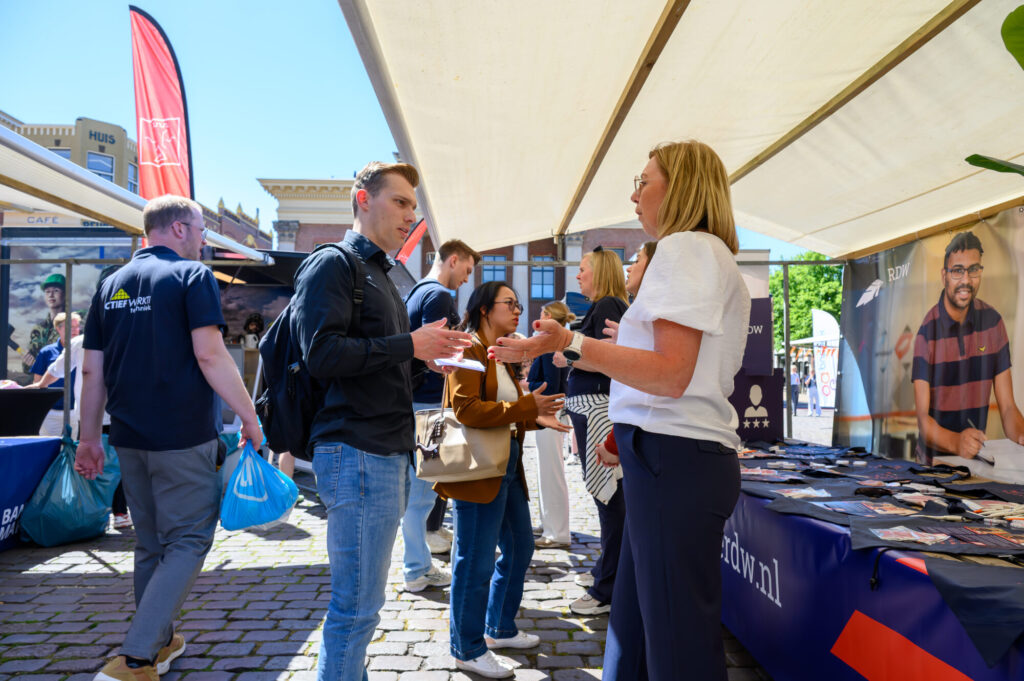 Bezoeker in gesprek met een standhouder op de banenmarkt