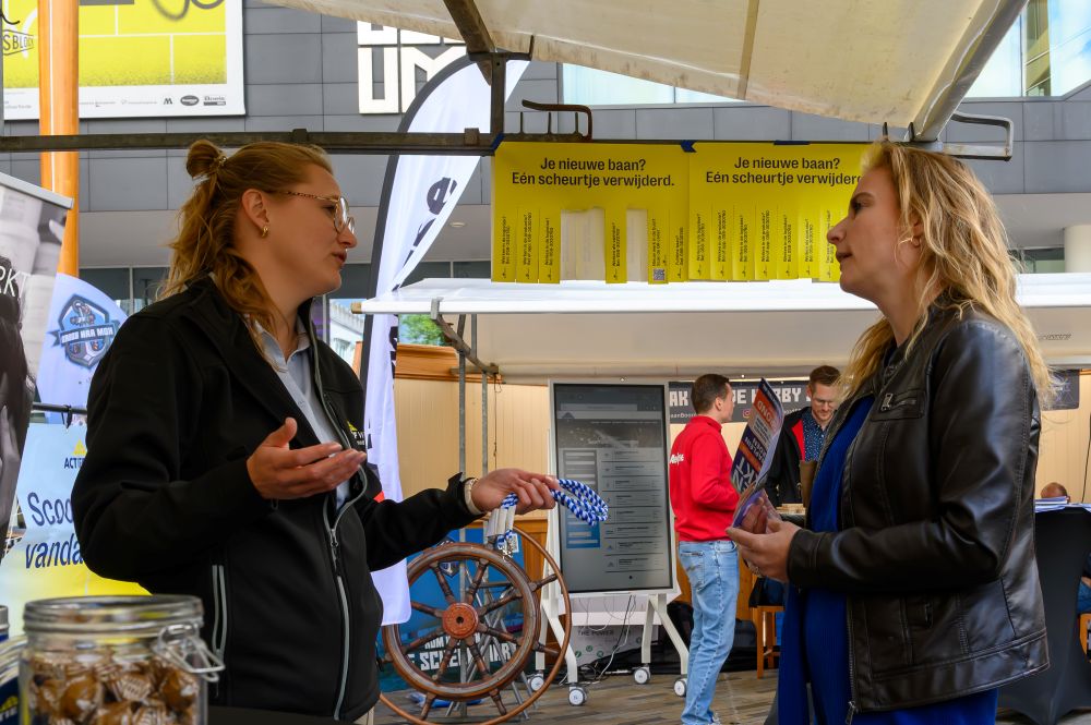 Bezoeker in gesprek met een standhouder op De Banenmarkt in Emmen