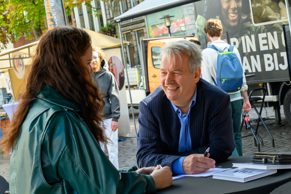 Werkzoekende in gesprek met een werkgever aan tafel op De Banenmarkt Groningen