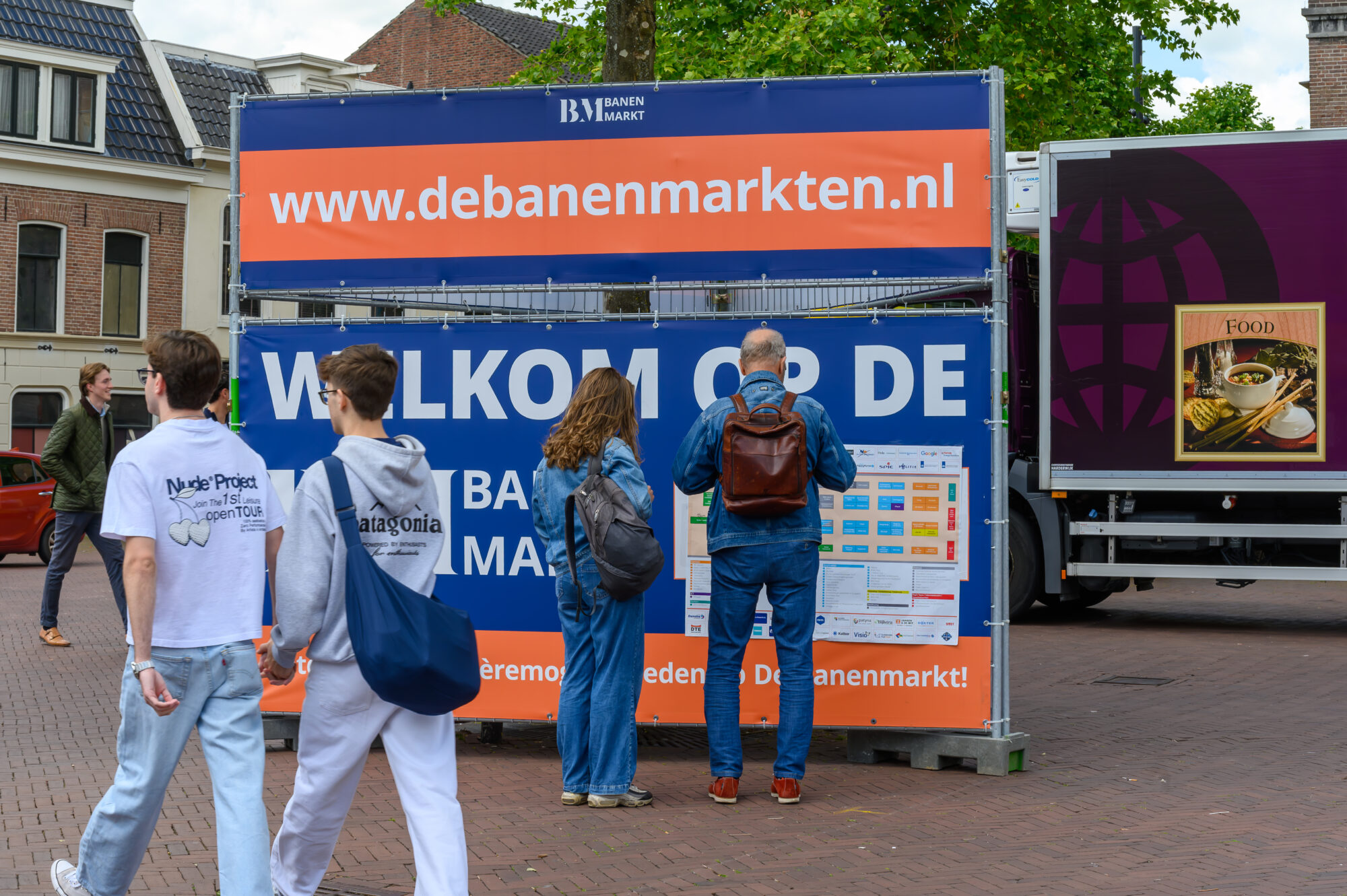 Bezoekers bekijken de plattegrond bij de welkomstbanner van De Banenmarkt Leeuwarden