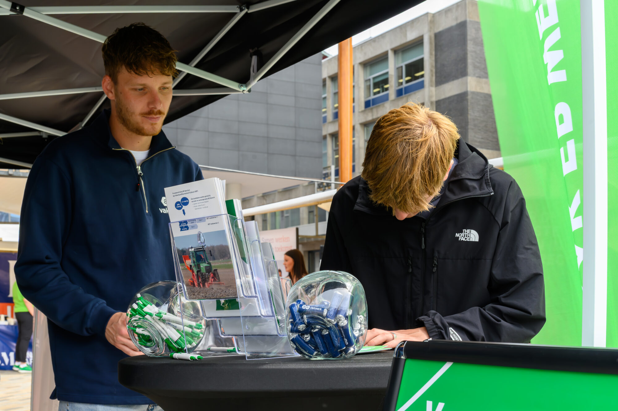 Bezoeker bekijkt informatie bij een kraam op De Banenmarkt Leeuwarden