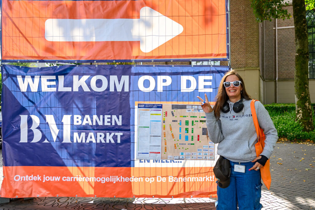 Bezoeker bij het welkomstspandoek met de plattegrond van De Banenmarkt Emmen op het Marktplein