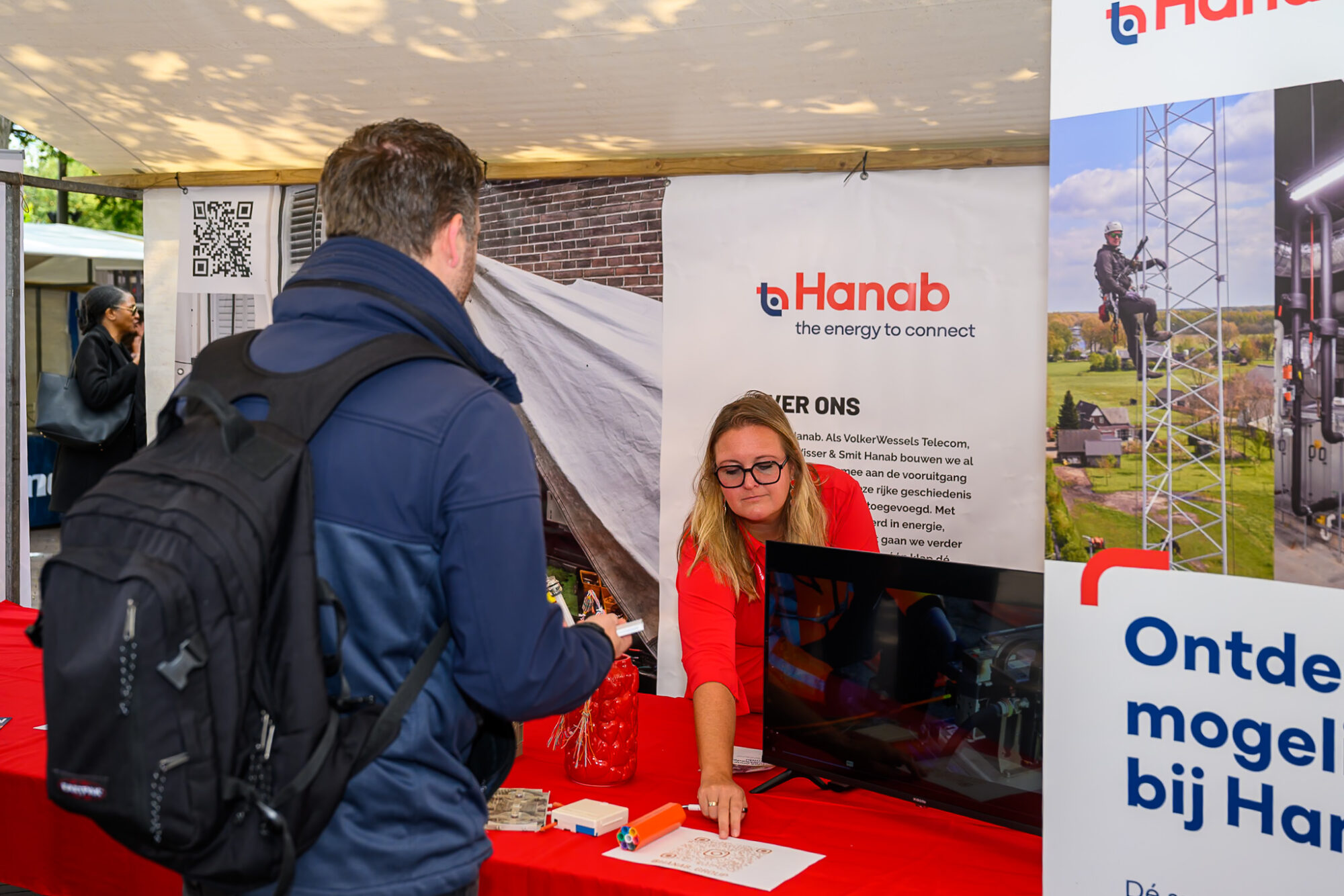 Bezoeker in gesprek met een medewerker van technisch bedrijf Hanab bij de stand op De Banenmarkt Emmen