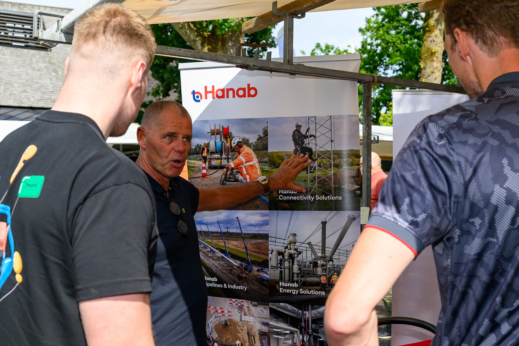 Medewerker van Hanab legt twee bezoekers uit welk technisch werk het bedrijf doet op De Banenmarkt Emmen