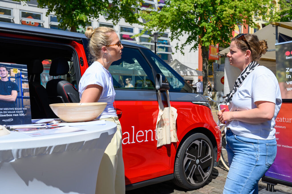 Standhouders in gesprek bij een bedrijfswagen op De Banenmarkt Groningen