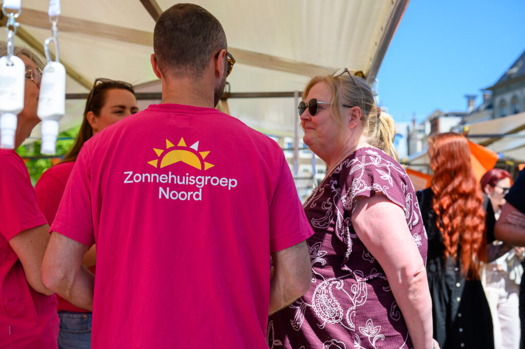 Medewerkers van Zonnehuisgroep Noord in gesprek met een bezoeker op De Banenmarkt Groningen