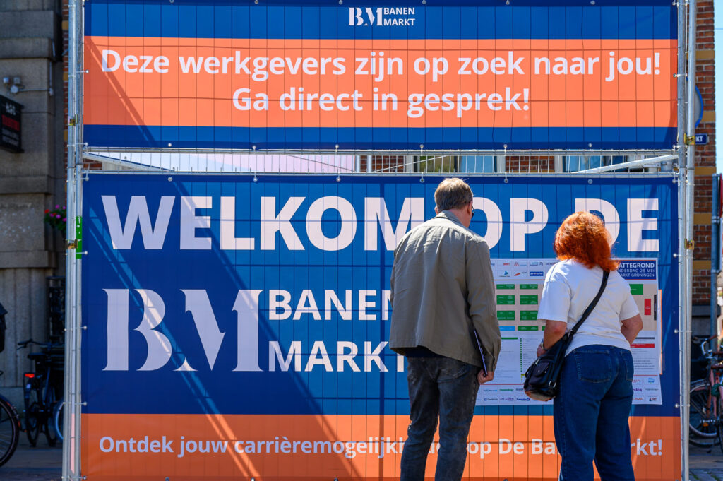 Bezoekers bekijken de plattegrond bij de welkomstbanner van De Banenmarkt Groningen