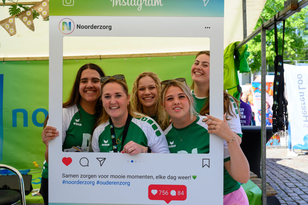 Zorgmedewerkers van Noorderzorg poseren met een fotolijst tijdens De Banenmarkt Groningen