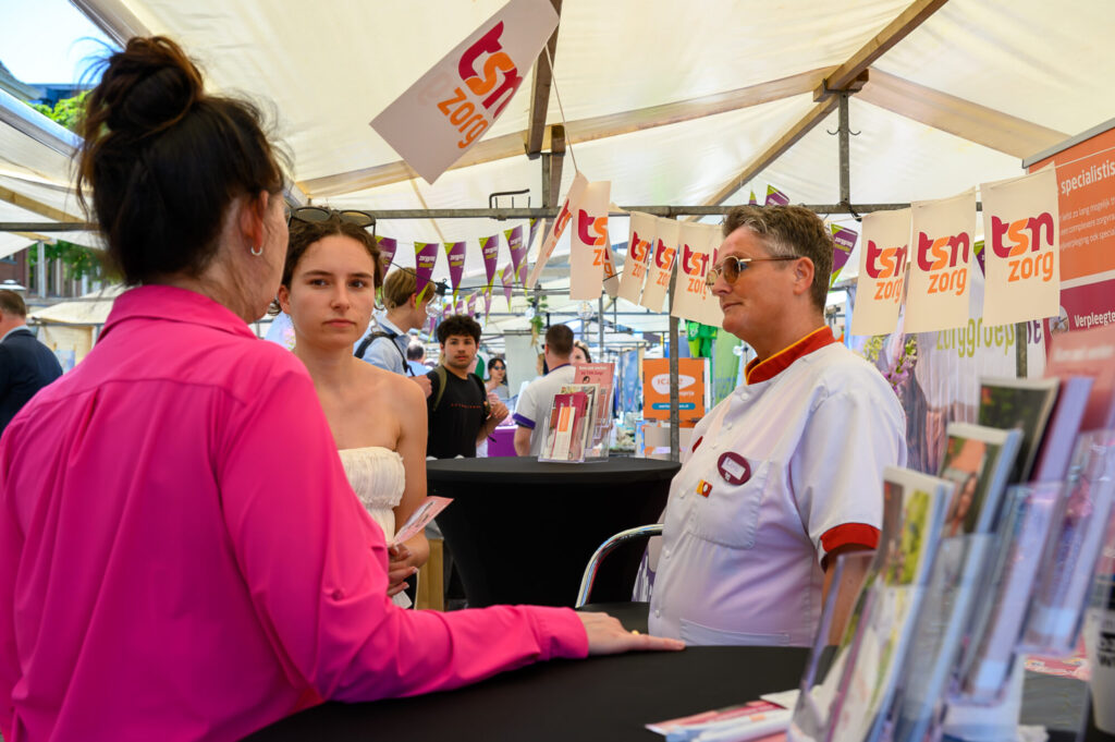 Verpleegkundige van TSN Zorg in gesprek met een bezoeker op De Banenmarkt Groningen