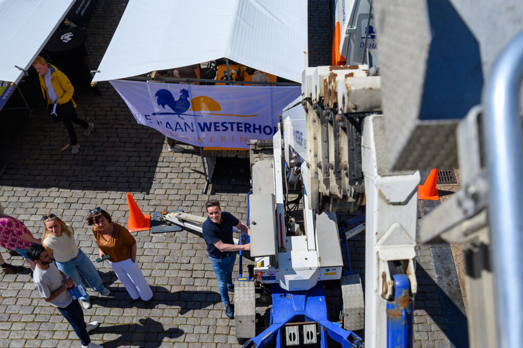 Hoogwerker bij een techniekstand op de Vismarkt tijdens De Banenmarkt Groningen